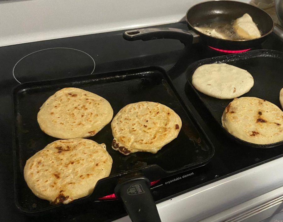 The golden pupusas are flipped on the stove.