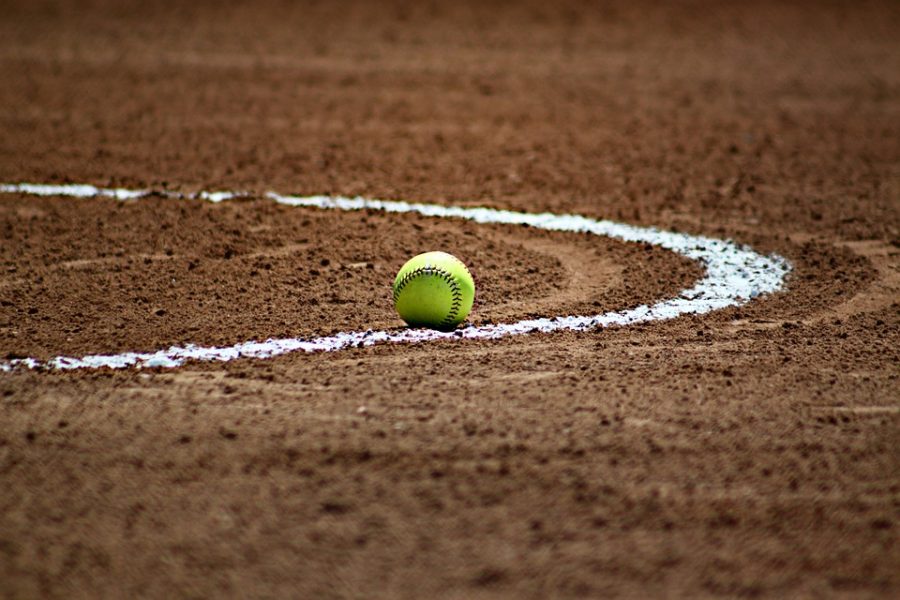 A softball lays on its field, untouched.