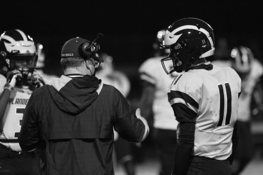 Coach Matt Townsend confers with a player on the sidelines.