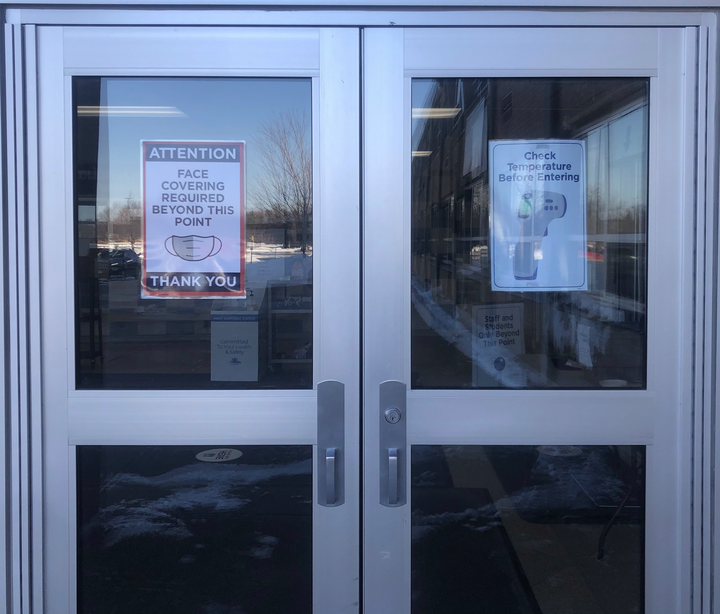 The doors to Columbia Heights High School remain plastered with info-graphic posters while staff plans for their vaccination.