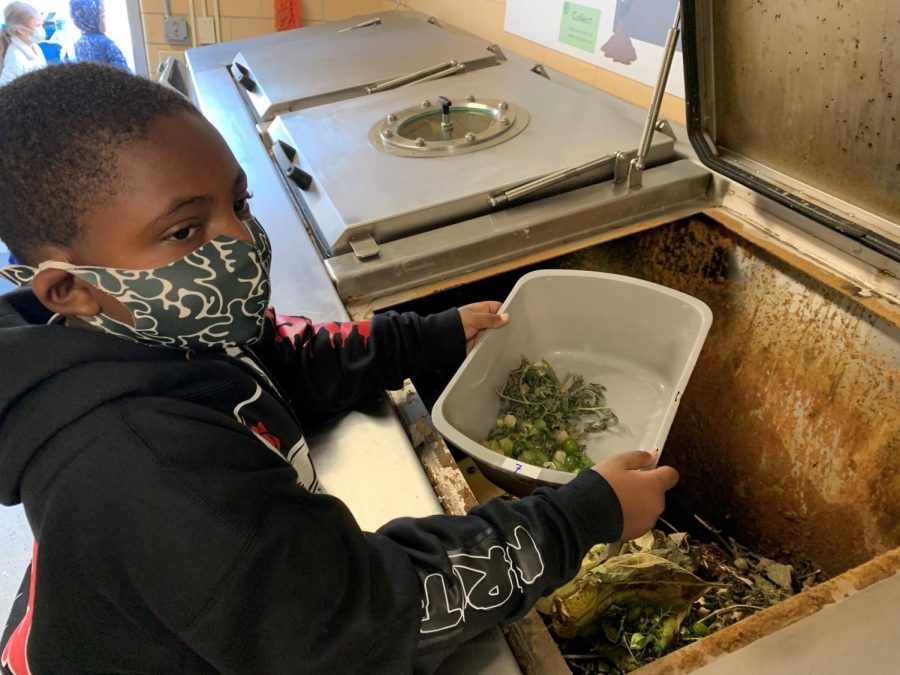 A student at North Park School for Innovation dumps food scraps into the biodigester, which will then become soil in approximately 24 hours.