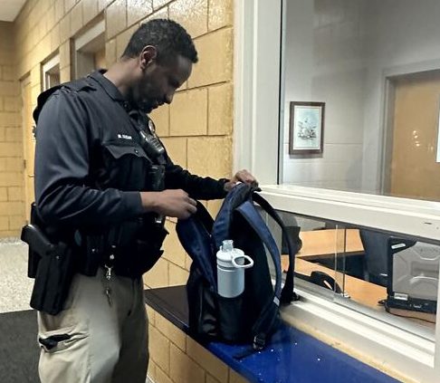 Youth Outreach Officer Mohammed Farah of the Columbia Heights Police Department (CHPD) checks a students backpack upon entrance at an after-school event at Columbia Heights High School (CHHS). 