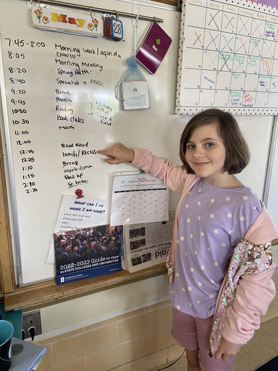 Phoebe Nelson points to her most-awaited time of the day on the classroom daily schedule — recess!