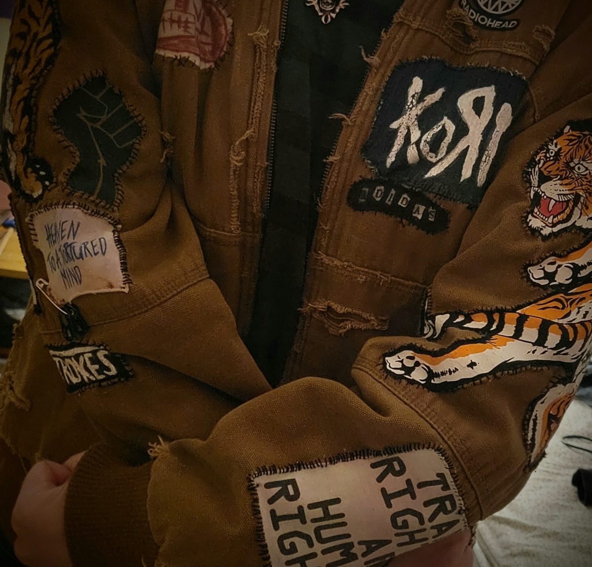 Ray Muhm (11) shows off his decked out jacket, which is studded with patches of alternative bands and human rights advocacy. 