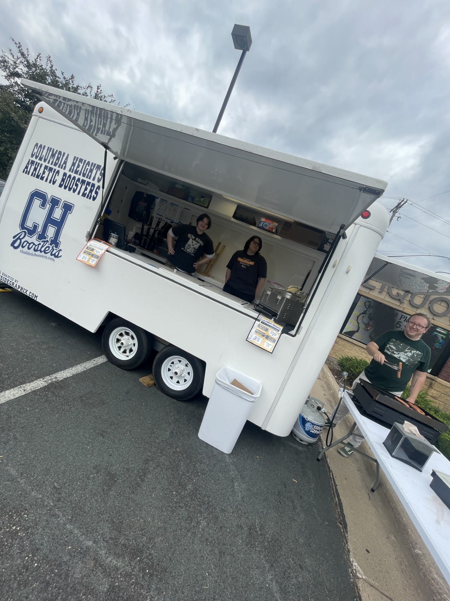 Feature Editor Skylen Raleigh and Staff Writer Finn Knoke-Borris volunteer at the Columbia Heights Activities Boosters hot dog wagon with Adviser Chris Polley to fundraise for The Heights Herald in 2024.