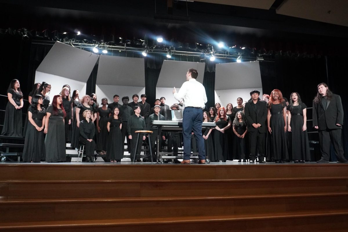 The Columbia Heights High School (CHHS) concert choir performs in the Performing Arts Center (PAC) with teacher Mr. Hollerman conducting.
