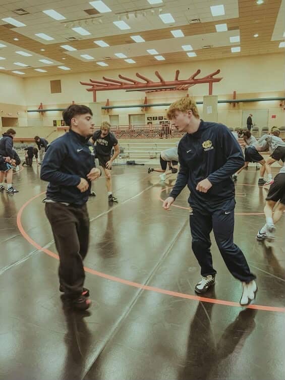 Two wrestlers prepare for a match by scrimmaging.